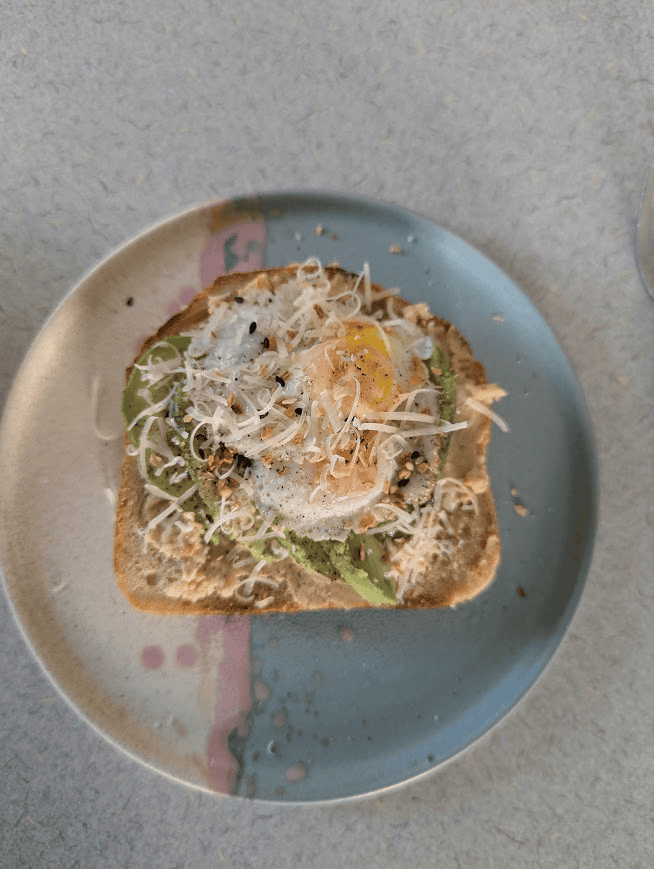 Ceramic plate loaded with hummus/avocado toast to feed a hungry gardener after she learned how to remove grass for a garden bed.